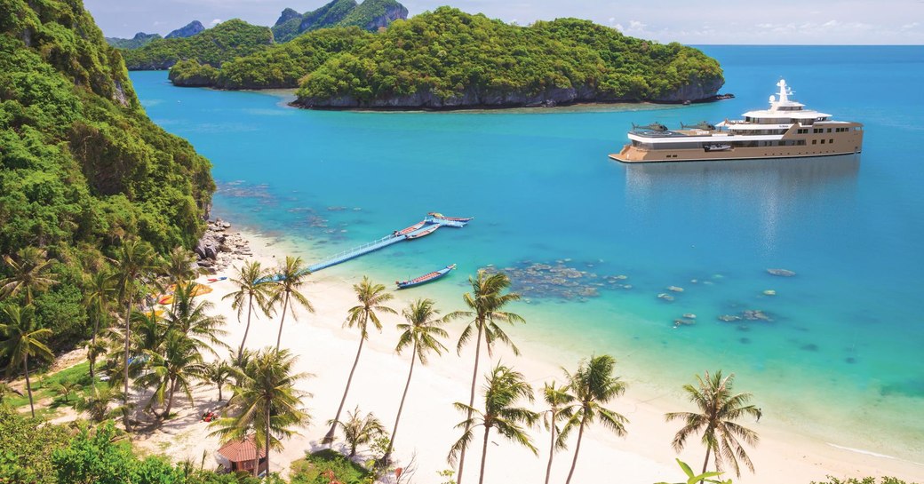 Charter yacht LA DATCHA at anchor in a bay by a paradisiac island