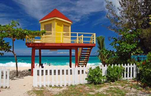 A yellow coastguard hut on a beach in Grenada