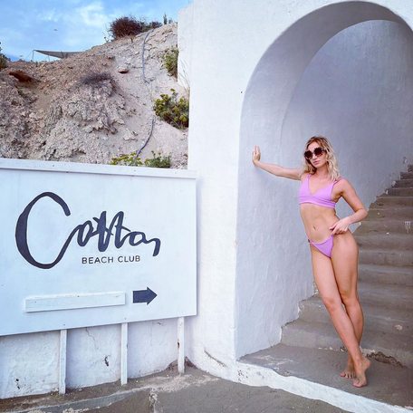 Visitor posing against Cotton's sign 