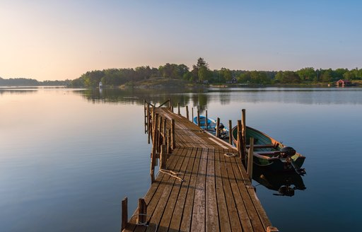 stunning picture of a pier going out with water and trees