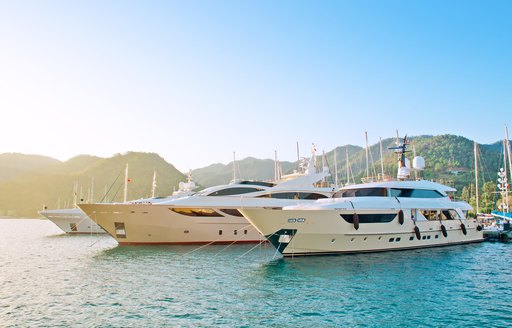 Yachts moored in a marina in Turkey with verdant hills in the background