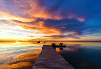 the sunsetting in cape cod creating a breathtaking scene for guests on a luxury yacht charter to enjoy asthey sip cocktails in the evening sun