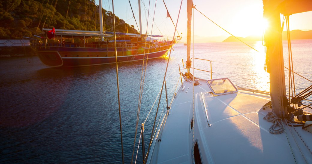 Sailing yacht and a gulet in Turkey against a setting sun