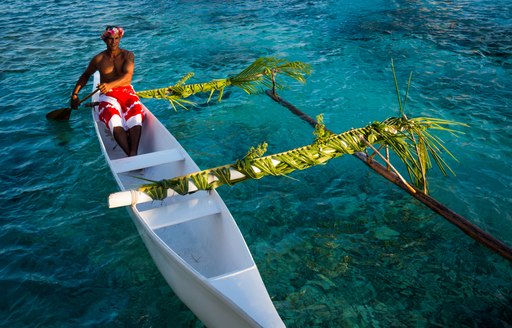 Local tahitian man was canoeing for food delivery in Tikehau island resort in French polynesia.